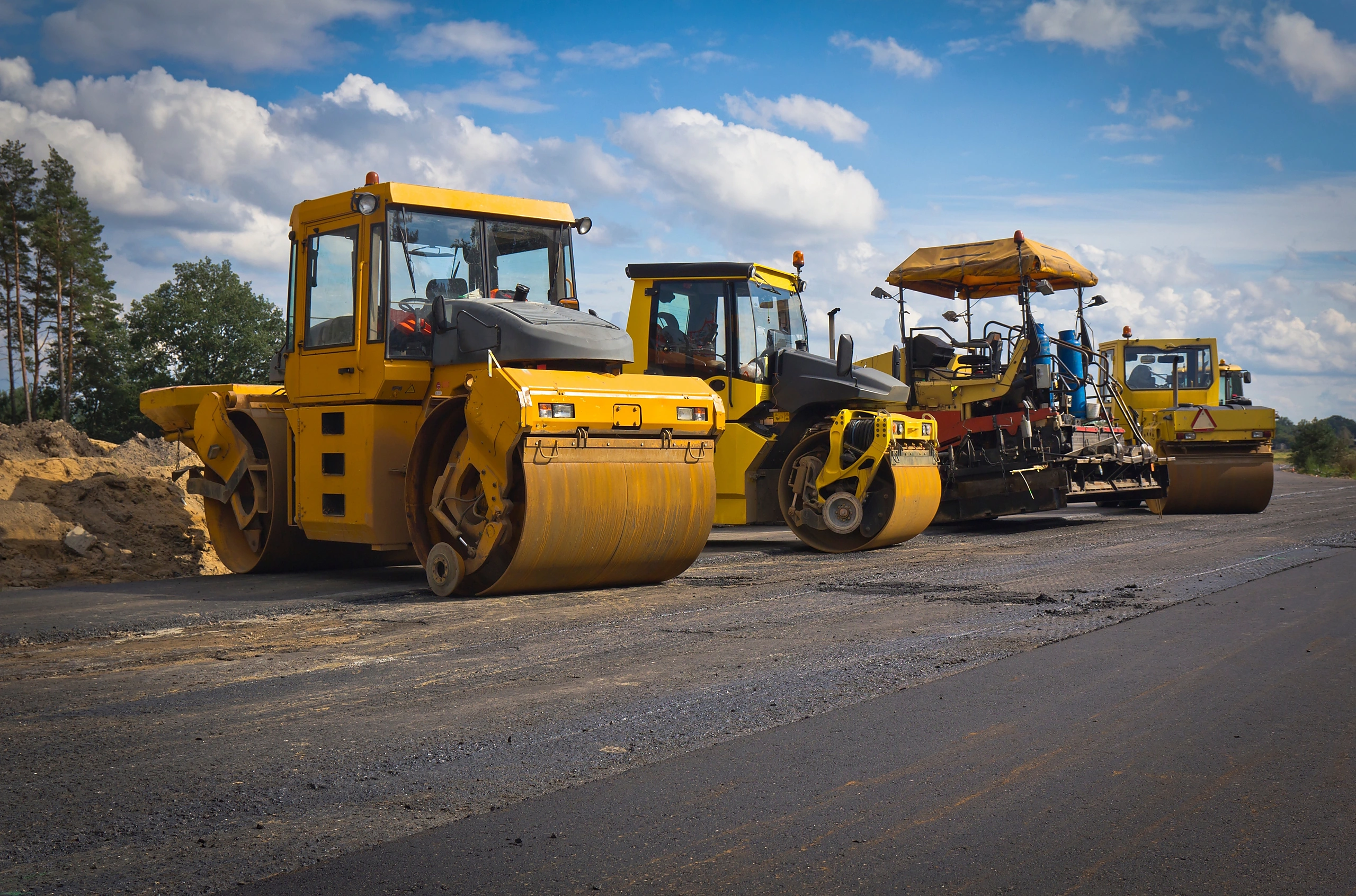Yellow road rollers and construction machinery on site